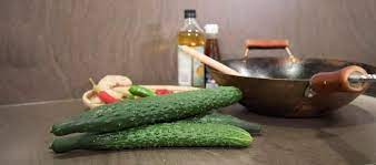 Wokcue Cucumbers next to a wok